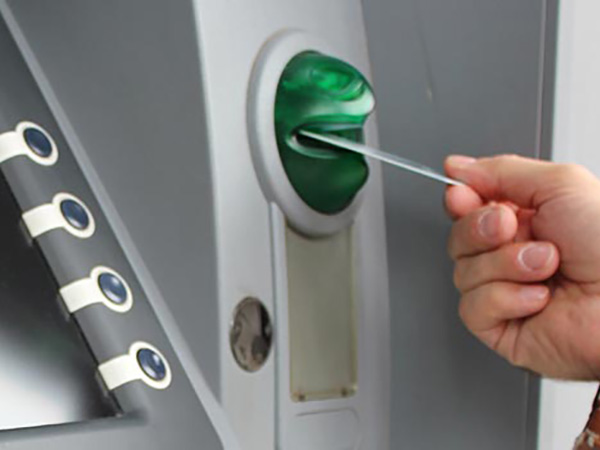 Photo of someone inserting a debit card into an ATM