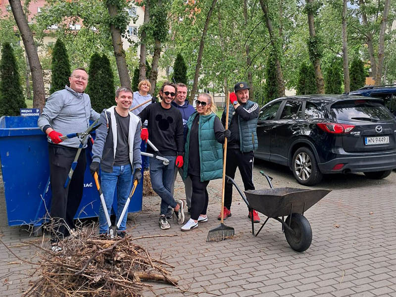 Euronet Polska employees planting flowers and tidying up the area around Fundacja Hospicjum Onkologiczne św. Krzysztofa in Warsaw.