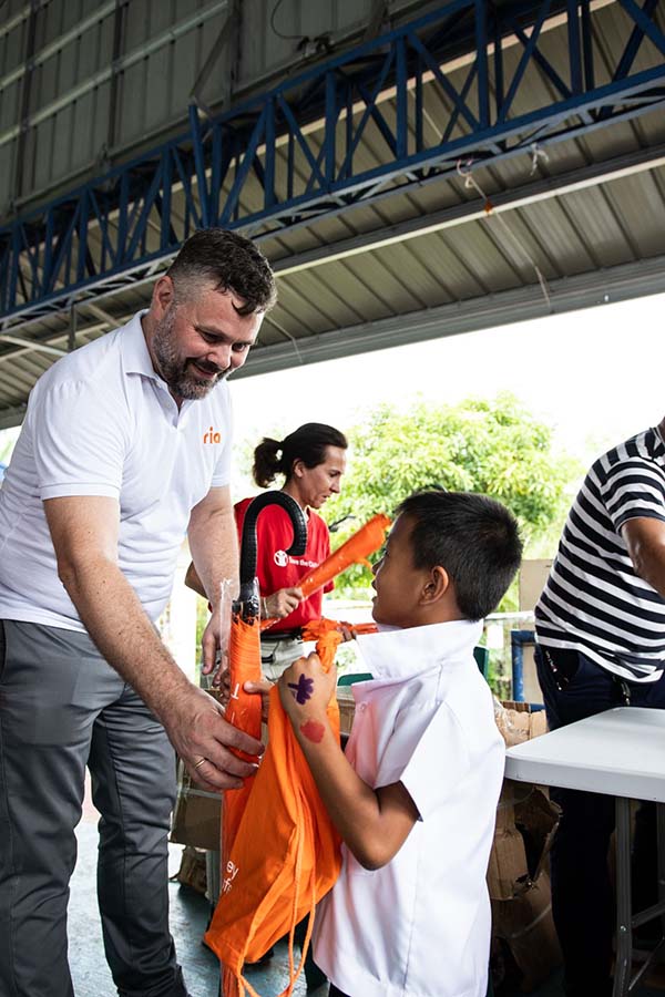 An image of Ria employees distributing supplies to children in the Philippines