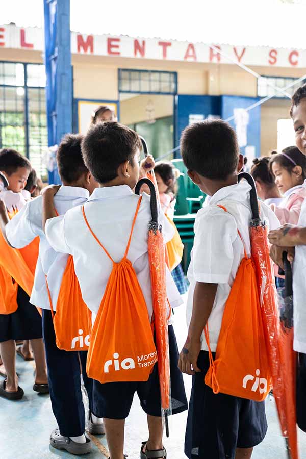 An image of Ria employees distributing supplies to children in the Philippines