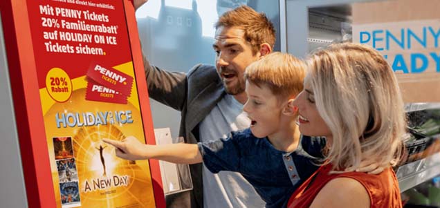 Photo of family buying an event ticket from a kiosk at a grocery store.